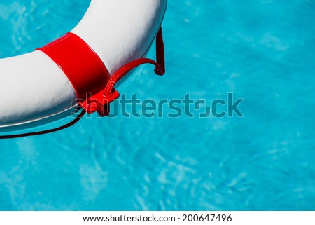 a rescue tire floating in a swimming pool. symbolic photo for rescue and crisis management in the financial crisis and banking crisis.