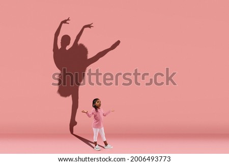 Silhouette of beautiful ballerina. Childhood and dream about big and famous future. Conceptual image with girl and shadow of female ballet dancer on coral pink wall. Sport, dreams, education concept. Royalty-Free Stock Photo #2006493773
