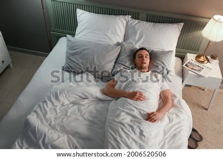 Young man snoring while sleeping in bed. Apnea problem Royalty-Free Stock Photo #2006520506