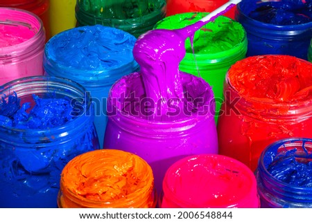 
Use a spoon to scoop the purple paint in the transparent glass bucket. 
colorful of ink background.