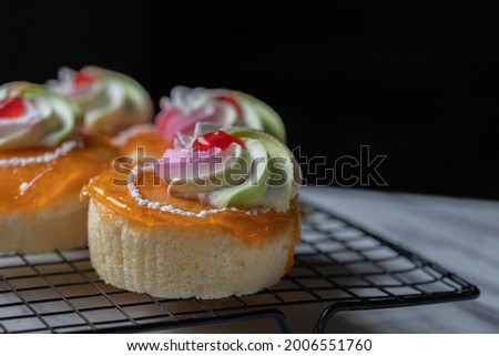 Vanilla orange cake with cream topping on marble table