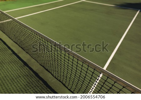 General view of tennis court and tennis net on sunny day. retreat, leisure time facilities and active lifestyle concept.
