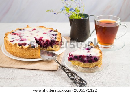 Homemade cake with black currants on a bright table. The concept of home tea drinking