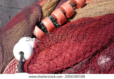 burgundy fishing net with white round buoys, fishing industry and industry theme
