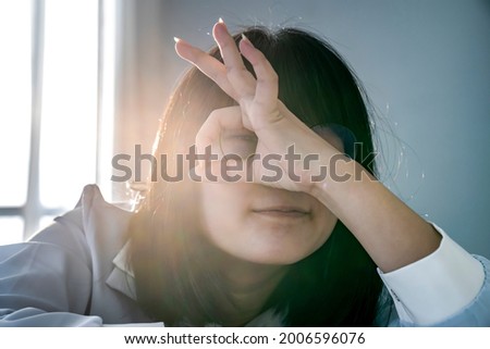 Young Glassese Asian Chinese - Thai girl is smiling happy doing OK sign with raising hand up on her eye looking through to camera.