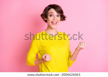 Photo portrait of happy model smiling gesturing like winner cheerful isolated on pastel pink color background