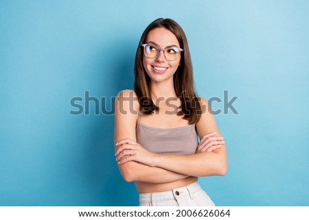 Photo portrait pretty woman curious wearing glasses looking empty space crossed hands isolated pastel blue color background