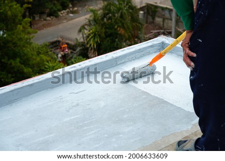 Hand painted gray flooring with paint rollers for waterproof, reinforcing net,Repairing waterproofing deck flooring. roof, floor.  Royalty-Free Stock Photo #2006633609