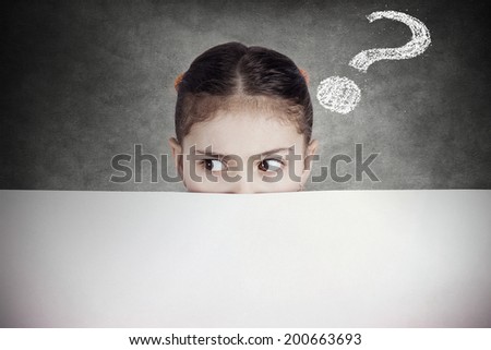 Closeup portrait little girl, suspicious, scared, cautious, curious, hiding behind blank white paper billboard, blank sign, space for text looking side way isolated black background with question mark