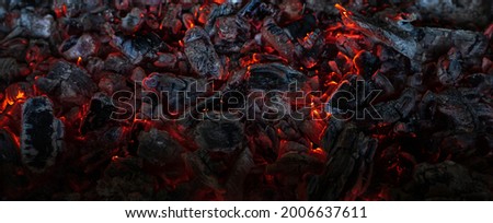 Burning coals in the dark, smoldering coal. Bright red sparks of fire. Background. Royalty-Free Stock Photo #2006637611