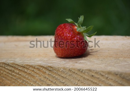 Juicy Strawberry on a Wooden Surface. Stock Photo