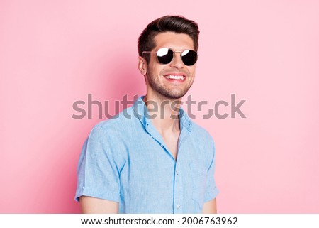 Portrait of attractive cheerful brunette guy wearing sun specs travel isolated over pink pastel color background
