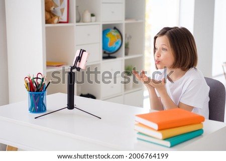 Profile side photo of young school girl pouted lips fooling study online look smartphone sit table education home