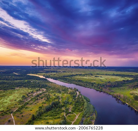 Rural summer sunset landscape with river and dramatic colorful sky, natural background, aerial view