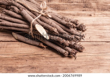 Bunch of raw Scorzonera or Spanish salsify. Very healthy modern vegetable, suitable for diabetics. Trendy ingredient for vegan or vegetarian food. Vintage wooden table, copy space Royalty-Free Stock Photo #2006769989