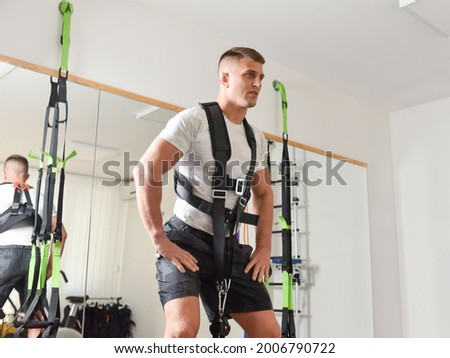 Handsome male working out on eccentric machine Royalty-Free Stock Photo #2006790722