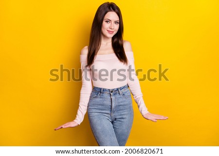 Photo of optimistic brunette lady wear pink shirt jeans isolated on vivid yellow color background