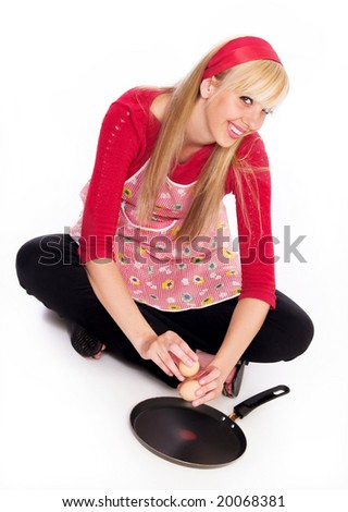 Young cook girl sit on belowa and holding egge on frying pan ,isolated on white