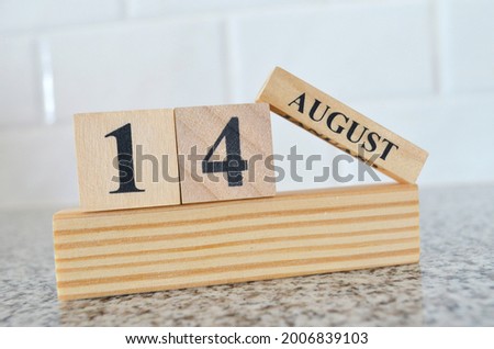 August 14, Cover design with number cube on a white background and granite table.