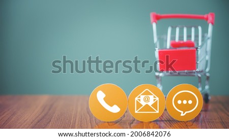 white contact symbol on yellow circle paper  with blurred shopping cart for contact us, call, mail or chat, question and answer ,new normal lifestyle, social distancing, online shopping and delivery