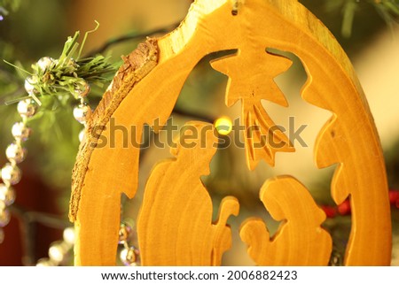 Part of a nativity scene carved in wood hanging on a Christmas tree. Royalty-Free Stock Photo #2006882423