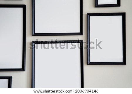 Different size framed photos hanging on the gray wall. High quality photo