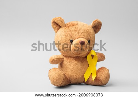 International Childhood Cancer Awareness month, Children toy with golden color Ribbon for supporting kids living. Healthcare and World cancer day concept Royalty-Free Stock Photo #2006908073