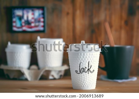 A cup of coffee on the coffee shop counter signed with the name "Jack". Signed coffee cups concept