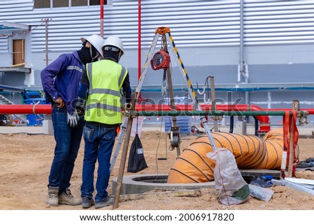 The safety officer and Engineering team discuss 
 working method before sending workers into a confined space. Royalty-Free Stock Photo #2006917820