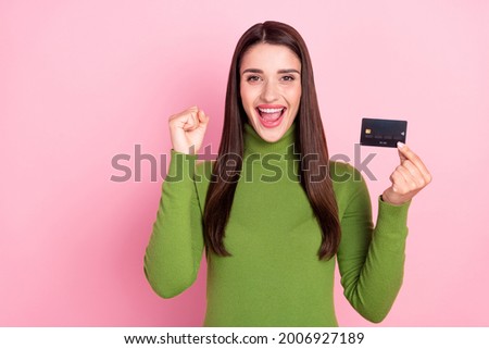 Photo of happy positive young woman winner hold hand credit card isolated on pastel pink color background