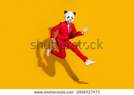 Photo of sporty energetic panda guy jump run wear mask red tux shoes isolated on yellow color background