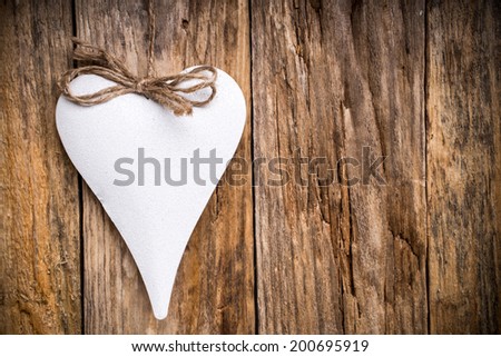 Heart on a wooden shelf. Wooden wall, studio photography.