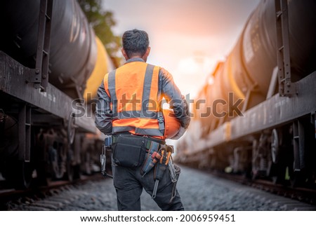 Photo back side engineers under inspection construction process railway switch and checking work on railroad station Engineer wearing safety uniform and safety helmet in work. Royalty-Free Stock Photo #2006959451