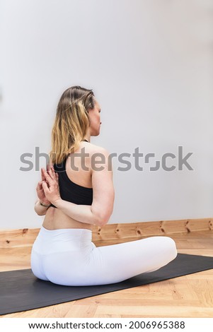 Russian blonde woman practicing asana Baddha Konasana yoga - Shoemaker's posture