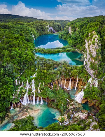 Plitvice, Croatia - Panoramic view of the beautiful waterfalls of Plitvice Lakes in Plitvice National Park on a bright summer day with blue sky and clouds and green foliage and turquoise water Royalty-Free Stock Photo #2006967563