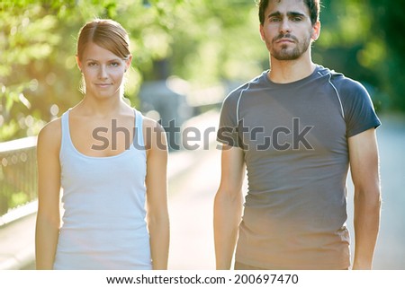 Photo of young sporty couple in activewear outdoors