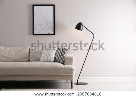 Stylish living room interior with comfortable sofa and floor lamp. Space for text Royalty-Free Stock Photo #2007034610