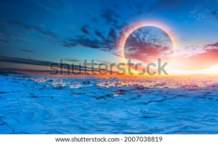 Ring of Fire - Solar eclipse with ice on the ocean shore "Elements of this image furnished by NASA"