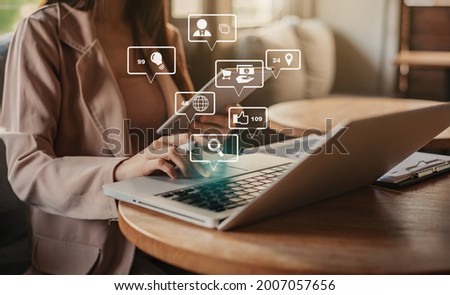 Social media and Marketing virtual icons screen of business women typing keyboard with laptop computer at office.