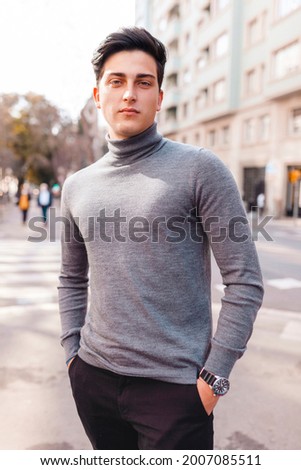 Portrait of young man wearing turtle neck looking at camera on the street  Royalty-Free Stock Photo #2007085511