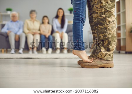 We've been waiting for you, daddy. Veteran soldier comes back home from the military. Closeup close up crop of father's and child's feet against blurred copyspace background of living room and family
