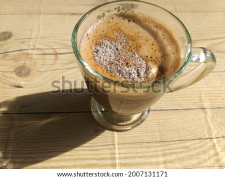 a cup of coffee is placed on the table on a yellow background