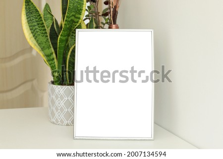 blank vertical photo frame in the room, mockup for arts