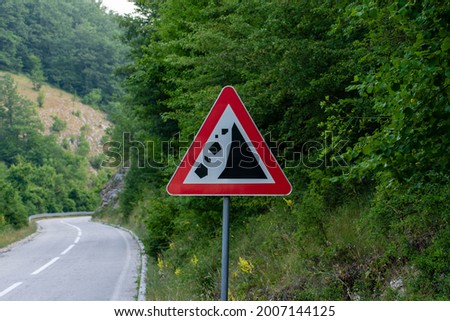A traffic sign warning of a landslide. Falling rocks or debris warning road sign.