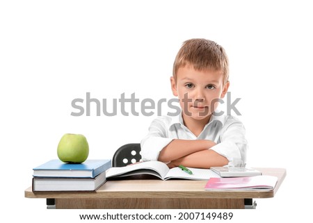 Little pupil sitting at school desk against white background Royalty-Free Stock Photo #2007149489