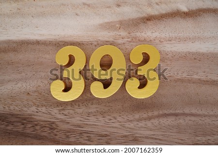 Gold numerals 393 on a dark brown to off-white wood pattern background.