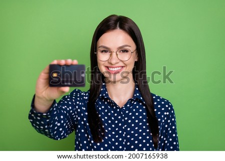 Photo of impressed brunette hairdo young lady show you card wear spectacles dotted shirt isolated on green color background