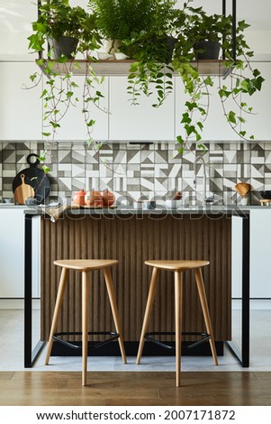 Stylish kitchen interior design with dining space. Workspace with kitchen accessories on the back ground. Creative walls. Minimalistic style an plant love concept. 