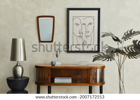 Stylish composition of creative living room interior with mock up poster frame, wooden commode, silver modern lamp, mirror, palm and elegant personal accessories. Neutral beige wall. Template.

