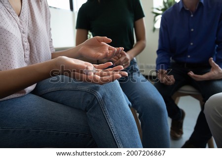 Team of anonymous addicted community meeting for group therapy, sitting on chairs in circle, talking, discussing social, mental health problems, getting counselling help and support. Close up of hands Royalty-Free Stock Photo #2007206867